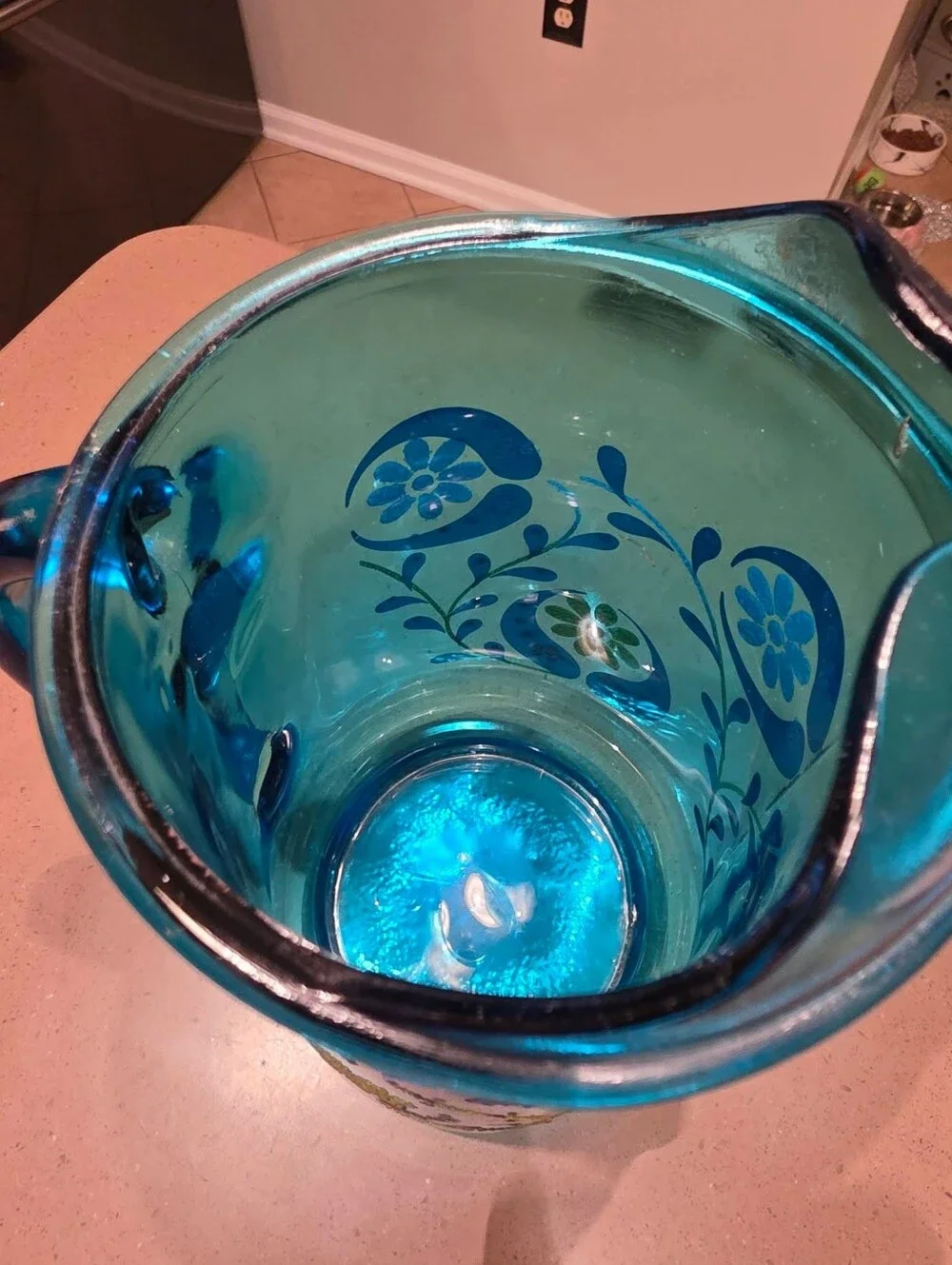 Vintage turquoise Libbey glass pitcher with painted design.